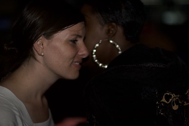 Two Women in Conversation at Dimly Lit Venue