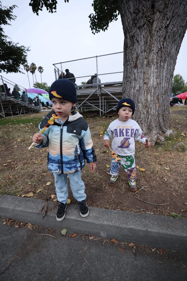 Two Young Boys Enjoying Candy Skewers at Balloon Festival