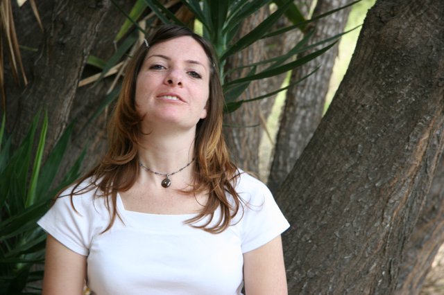 Woman Smiling Serenely Beneath Tropical Trees
