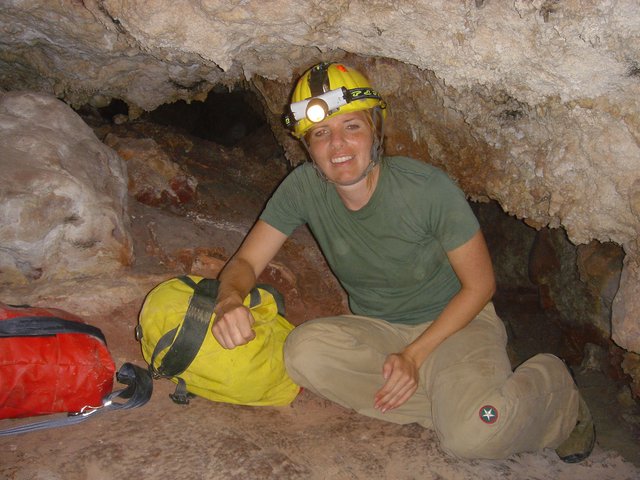 Underground Explorer Poses in Limestone Cave Passage
