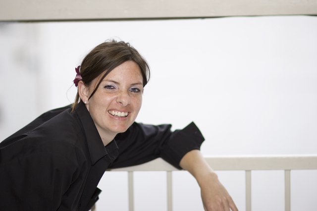 Smiling Woman Leaning on White Railing Outdoors