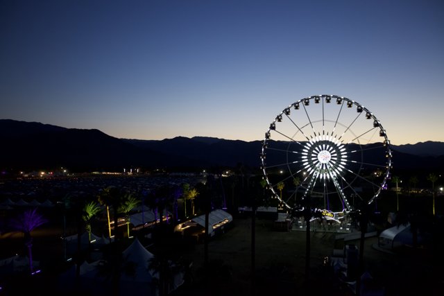 Gleaming Ferris Wheel Against Mountain Vista