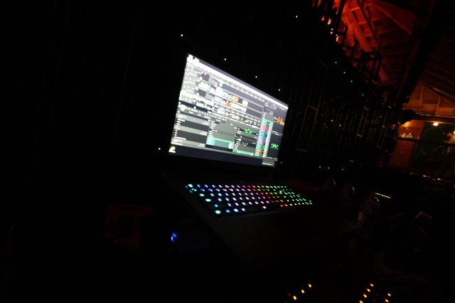 DJ Laptop Setup Glowing at Dark Festival Stage