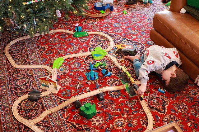 Child Playing with Wooden Train Set on Christmas Day