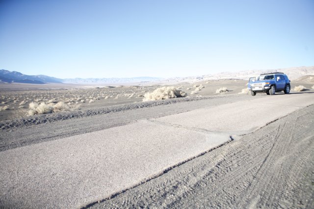 Driving through the Desert in a Blue Jeep