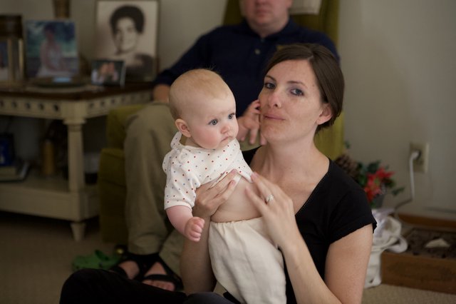 Mother Holding Infant at Family Gathering Indoors