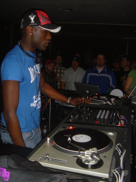 Blue-Shirted Man DJs at Nightclub