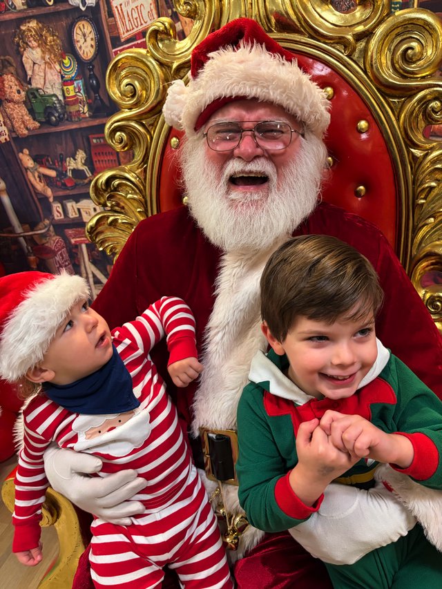 Two Children Visit Santa in His Festive Workshop