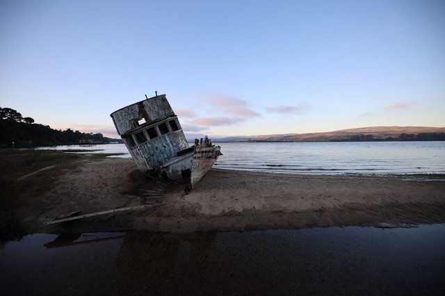 Abandoned Shipwreck at Twilight on Coastal Beach