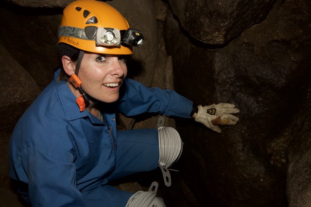 Caver Explores Underground Passage with Headlamp