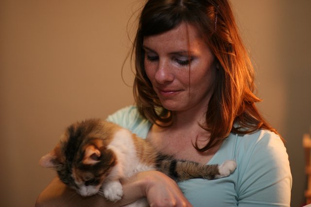 Woman Cradling Sleeping Calico Kitten Tenderly