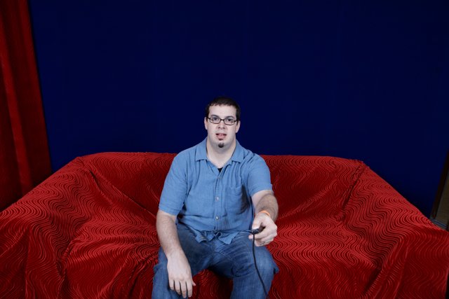 Dave B sitting on a Velvet Red Couch