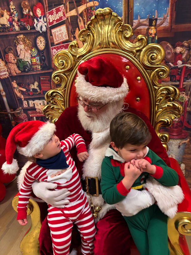 Two Children Visit Santa in His Toy Workshop