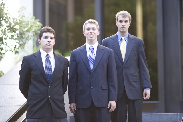 Three Men in Suits Stand Tall