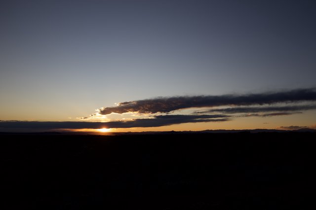 Dramatic Sunset Over Dark Desert Landscape
