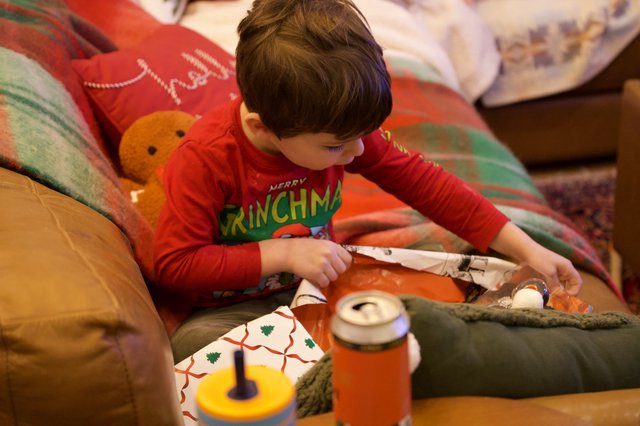 Child Opening Christmas Presents on Christmas Morning