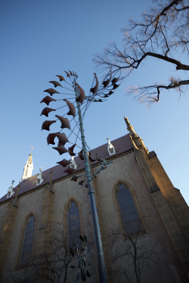 Metal Phoenix Sculpture Against Historic Church at Dusk