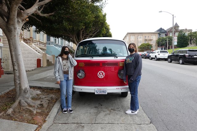 Friends Pose with Classic Red Volkswagen Bus