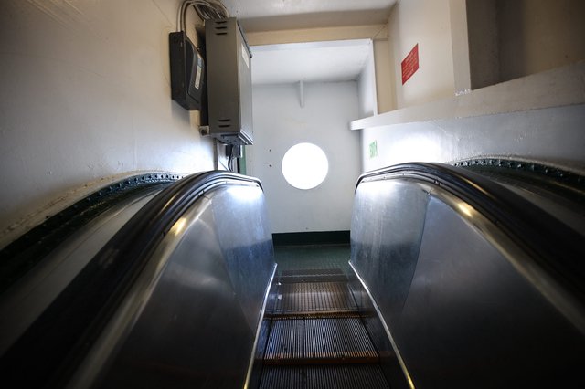 Descending Escalator into Industrial White Corridor