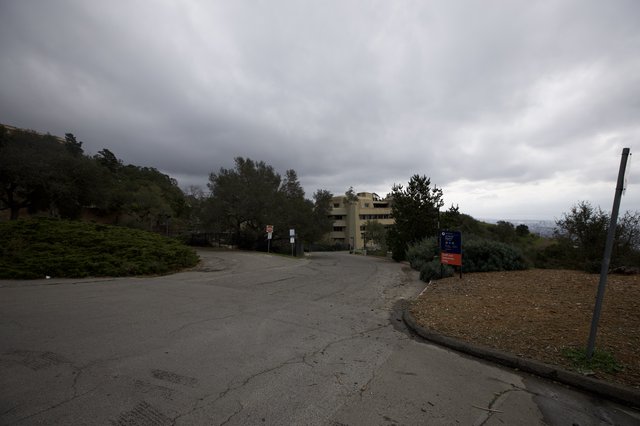Overcast Hillside Road Leading to Multi-Story Building