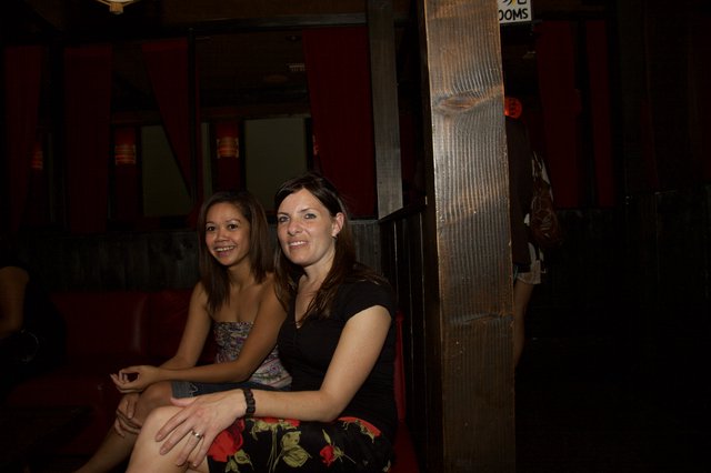 Two Women Smiling at a Dimly Lit Bar