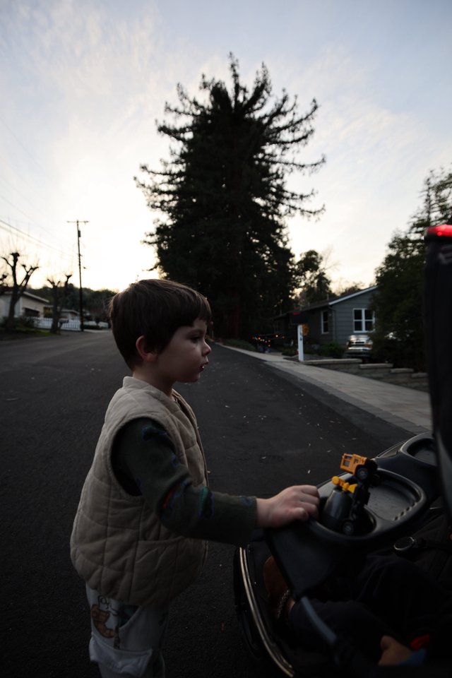 Boy with Toy Car on Suburban Street at Dusk