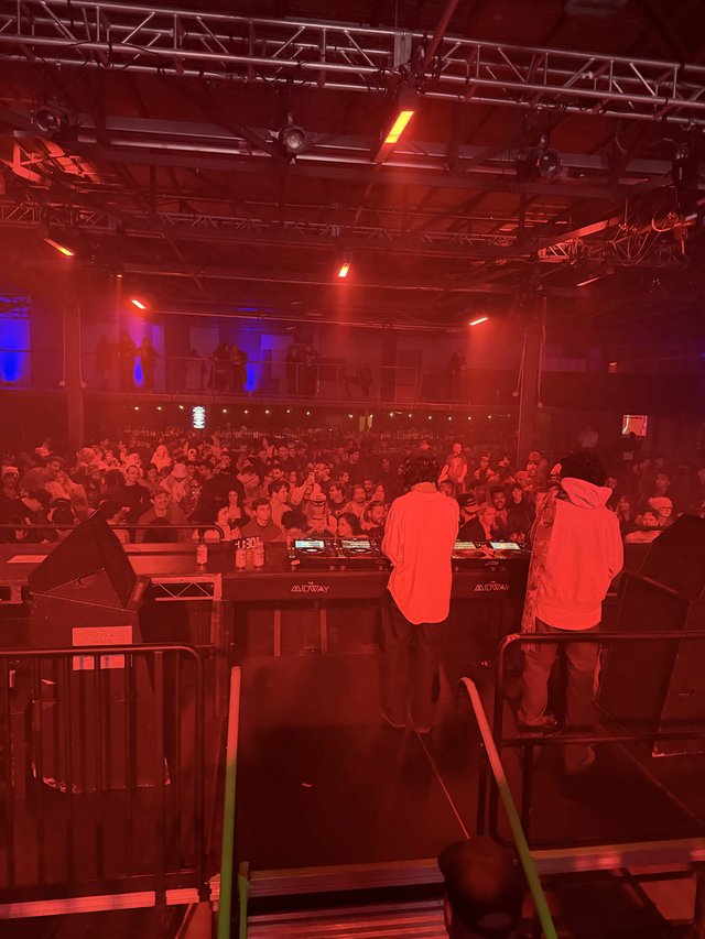 DJ Performance at Electronic Music Venue Under Red Stage Lights