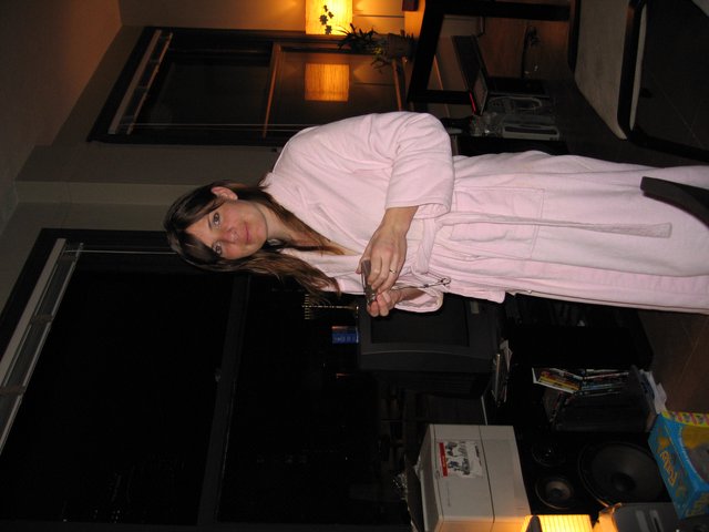 Woman in Pink Robe Standing in Dimly Lit Apartment