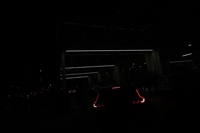 Glowing Taillights Queue at Night Festival Entrance