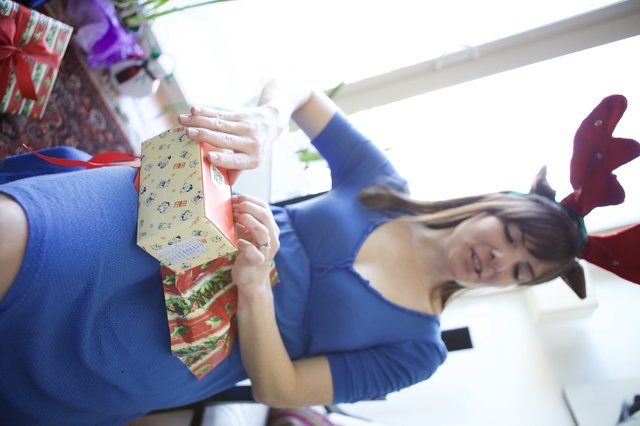 Reindeer-Antlered Woman Unwrapping Christmas Gift Joyfully