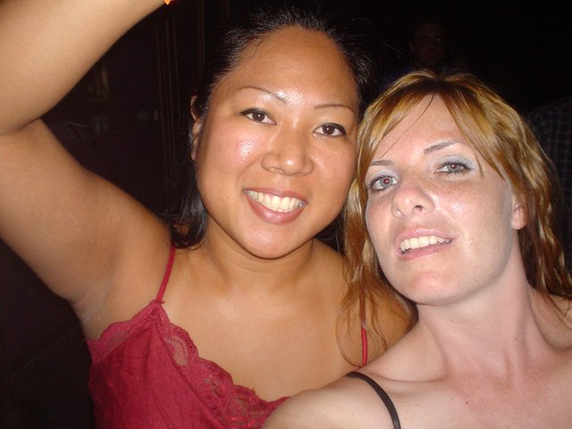 Two Friends Smiling Together at a Nighttime Event