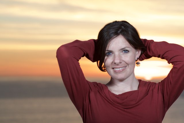 Radiant Woman Smiling at Sunset by the Sea