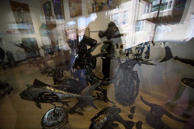 Metal Sculptures Displayed Behind Gallery Window Reflections