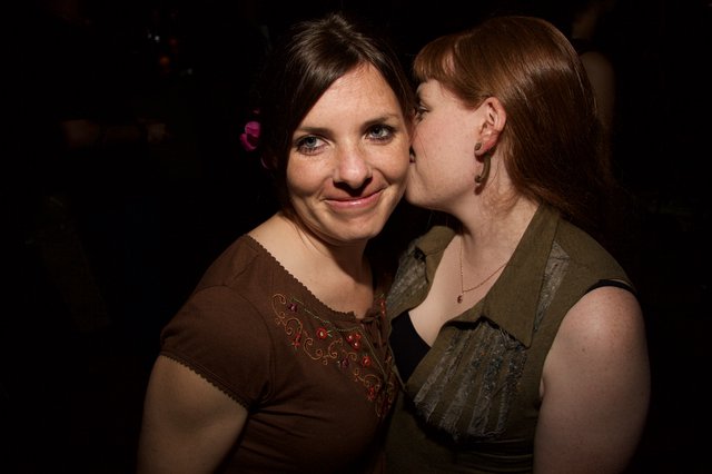 Two Friends Share a Playful Kiss at Art Walk