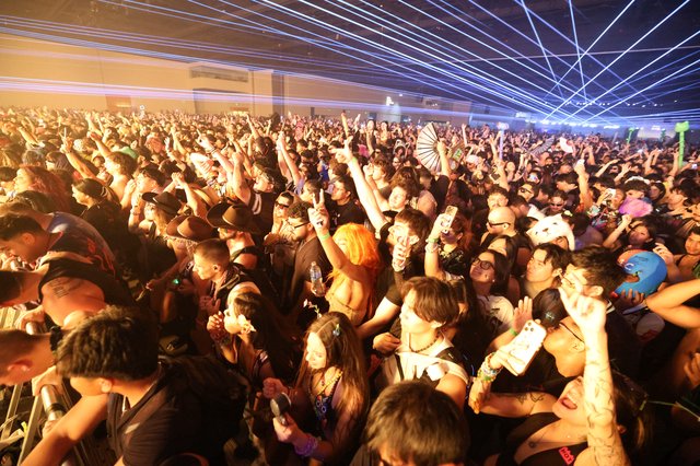 Massive Indoor Rave Crowd Under Electric Laser Light Show