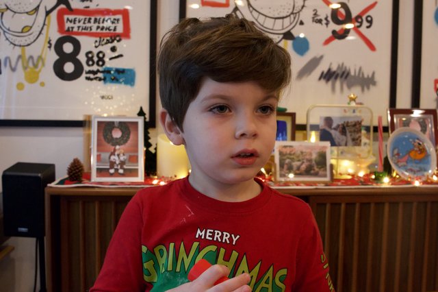 Young Child in Festive Grinchmas Sweater at Christmas