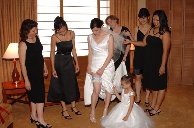 Bride Adjusts Garter Surrounded by Wedding Party