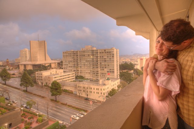 New Parents Embrace Newborn on San Francisco Balcony
