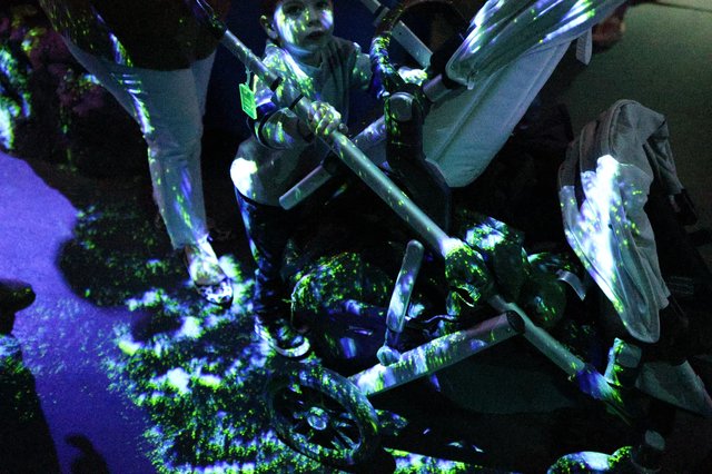 Memorial Vigil with Candles and Flowers Under UV Light