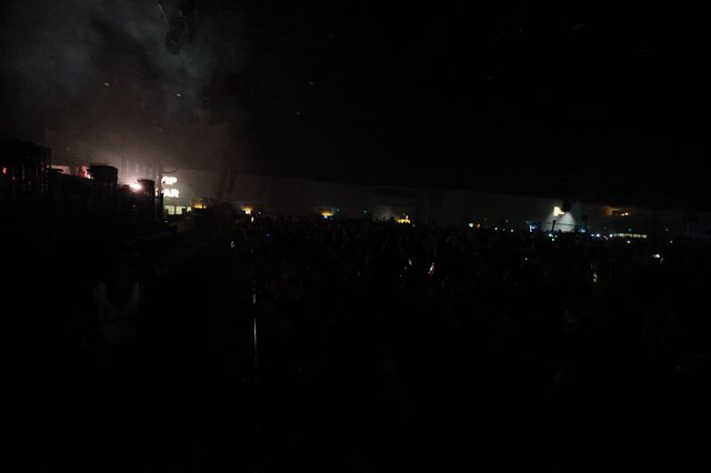 Massive Crowd Engulfed in Festival Fog and Darkness