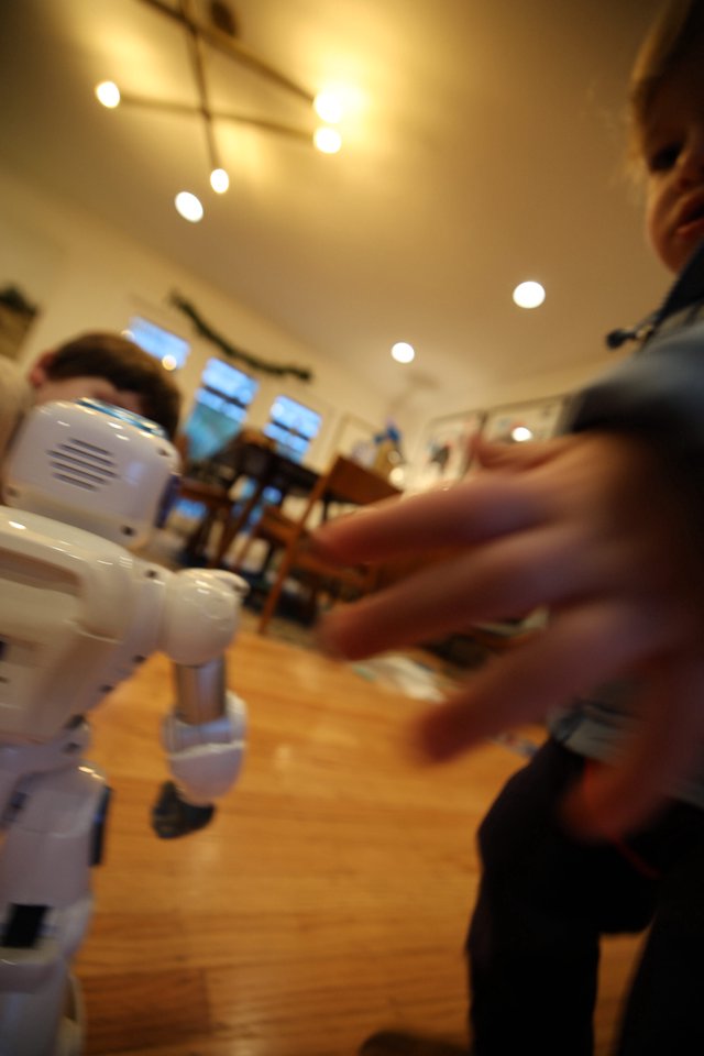 Child Interacting with Small White Robot at Home