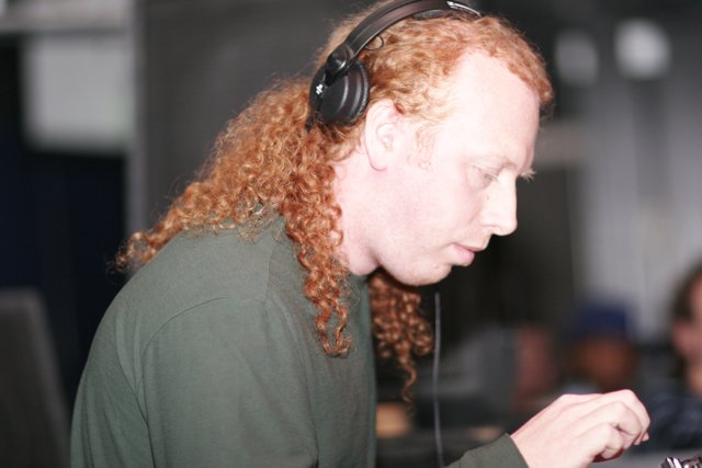 Red-Haired DJ Grooving with Headphones