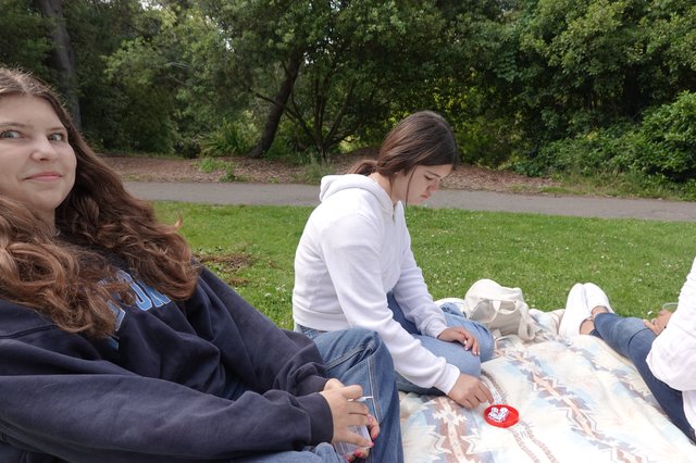 Friends Relaxing on Picnic Blanket in Park