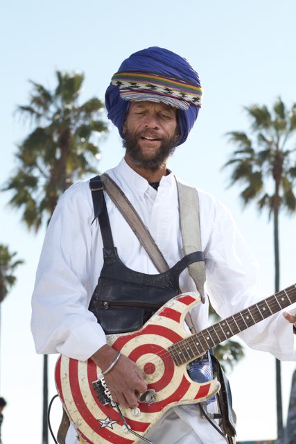Turbaned Guitarist Jamming by the Palm Trees