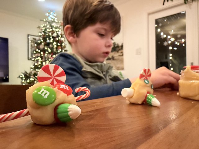 Child Decorating Gingerbread House on Christmas Eve