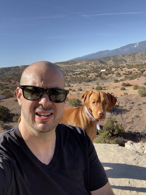 Man and His Furry Friend Take in the Mountain Views