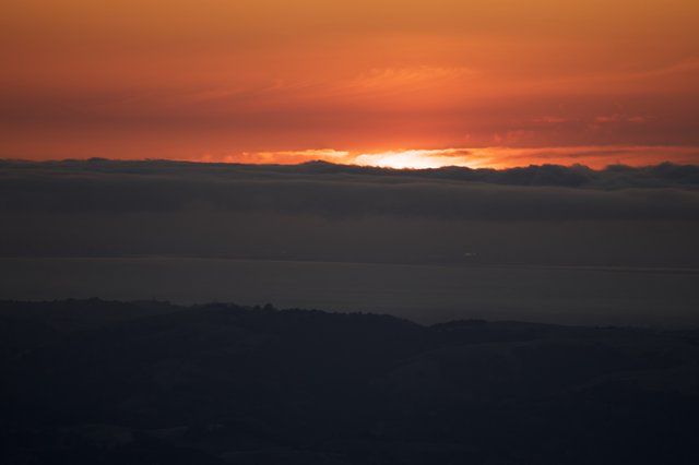 Fiery Sunset Ignites the Horizon Beyond Bay Clouds