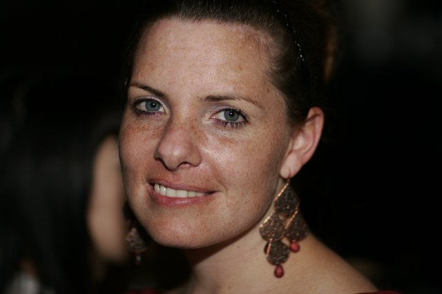 Freckled Woman Smiling at Evening Social Event
