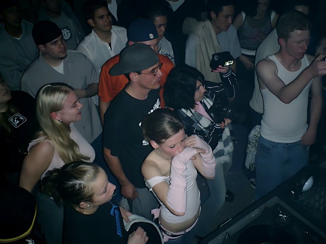 Nightclub Crowd Gathers around DJ