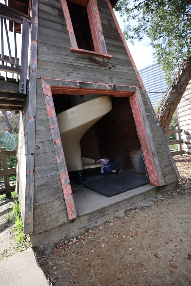 Child Playing in Weathered A-Frame Playhouse Structure